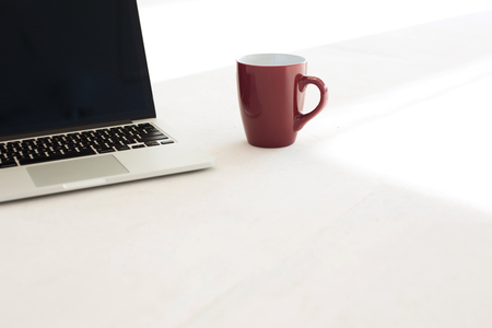 Laptop and coffee cup on floor of officeの写真素材