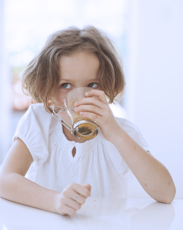 Close-up view of Young girl drinking cup of teaの写真素材