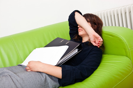 Businesswoman sleeping on a sofaの写真素材