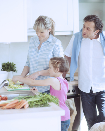 Family making a healthy salad in the kitchenの写真素材