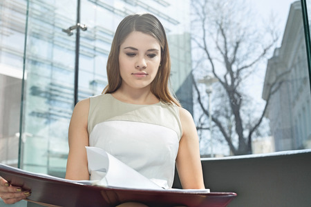 Businesswoman reading file in officeの写真素材