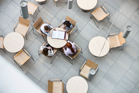 High angle view of businesswomen doing paperwork in office canteenの写真素材