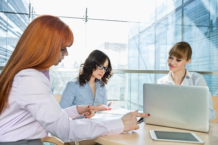 Businesswomen working at table in officeの写真素材