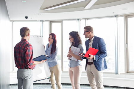 Businesswoman giving presentation to colleagues in creative officeの写真素材
