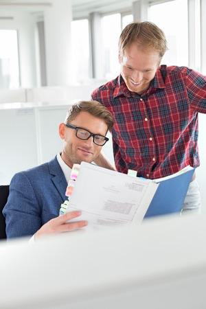 Businessmen reading file in creative officeの写真素材