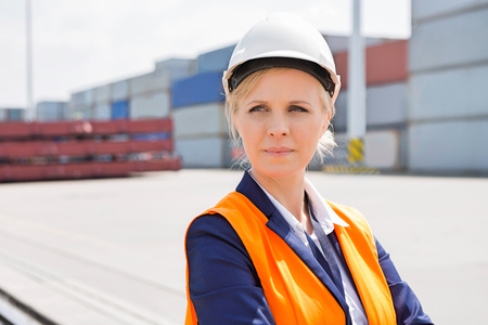 Beautiful female engineer looking away in shipping yardの写真素材