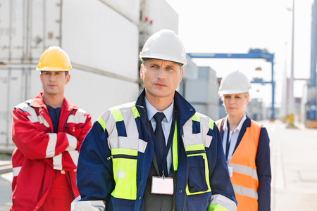 Confident workers standing in shipping yardの写真素材