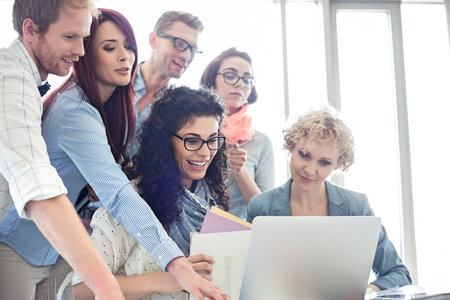 Group of creative businesspeople using laptop in officeの写真素材