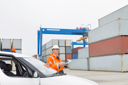 Middle-aged man examining cargo in shipping yardの写真素材