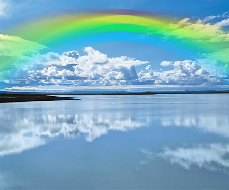 Rainbow over calm lakeの写真素材