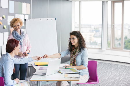 Businesswomen working together in creative officeの写真素材