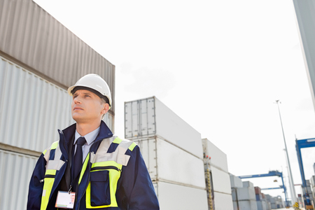 Middle-aged male worker looking away in shipping yardの写真素材