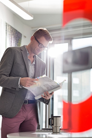 Businessman reading file in creative officeの写真素材