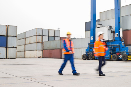 Full-length of workers walking in shipping yardの写真素材