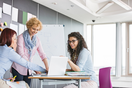 Businesswomen working together in creative officeの写真素材