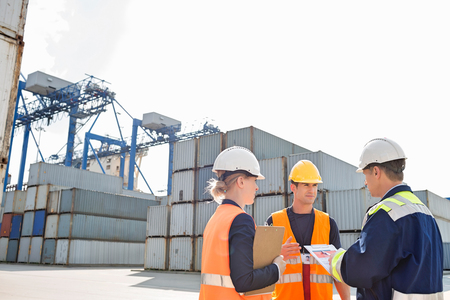 Workers discussing in shipping yardの写真素材