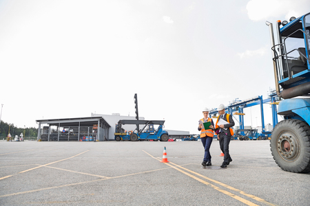 Full-length of workers walking in shipping yardの写真素材