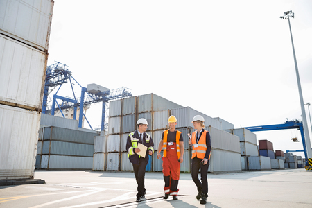Full-length of workers walking in shipping yardの写真素材