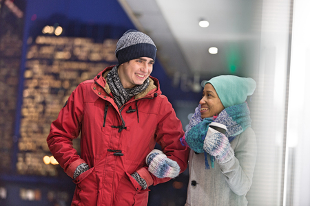 Multiethnic couple conversing at dusk during winterの写真素材