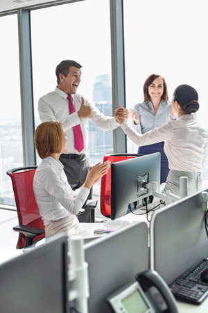 Businesspeople celebrating success in officeの写真素材
