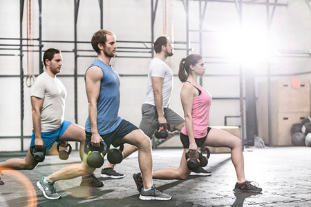 Determined people lifting kettlebells at crossfit gymの写真素材