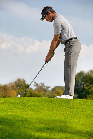 Young man playing golfの写真素材