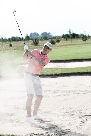Middle-aged man playing at golf courseの写真素材