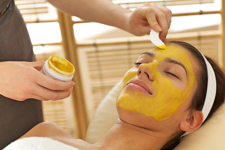 Close-up of young woman having facial mask in beauty parlorの写真素材