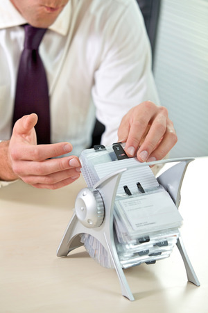 Businessman searching business card from standの写真素材