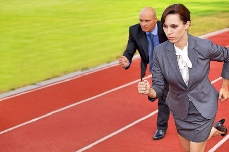 Businessman and woman on running on race trackの写真素材