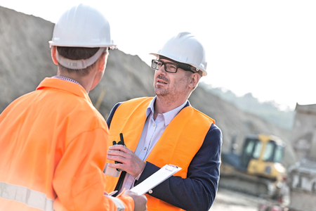 Architects discussing at construction site on sunny dayの写真素材