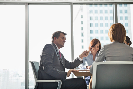 Businessman discussing with female team in conference roomの写真素材