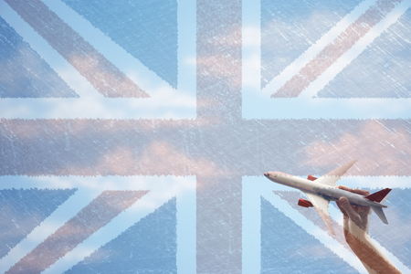 Toy plane flying in front of Union Jack flagの写真素材
