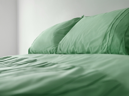 Green bedding on bedの写真素材
