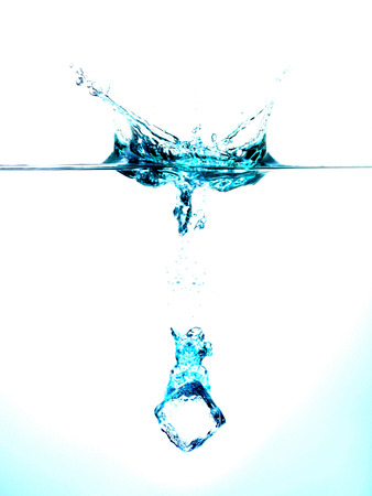 Ice cubes splashing into clear water surface viewの写真素材