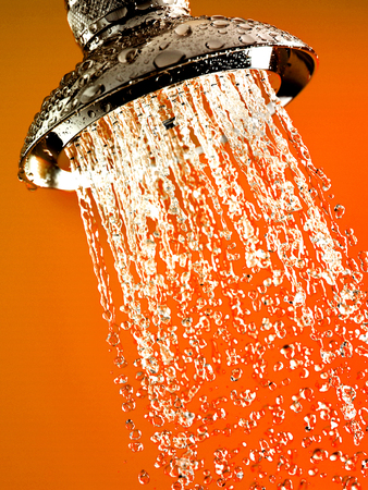 Close-up of water flowing out of chrome shower headの写真素材