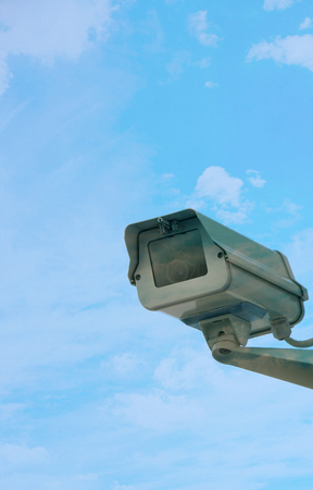 Security camera on wall against cloudsの写真素材