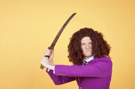 Caucasian man with afro wearing Purple Suit carrying swordの写真素材