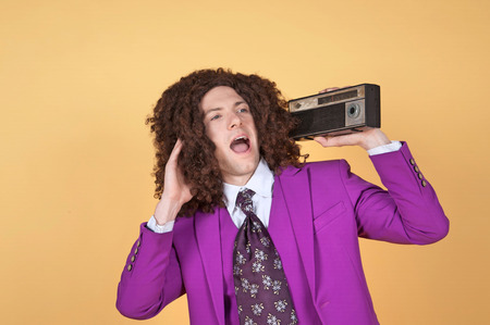 Caucasian man with afro wearing Purple Suit listening to musicの写真素材