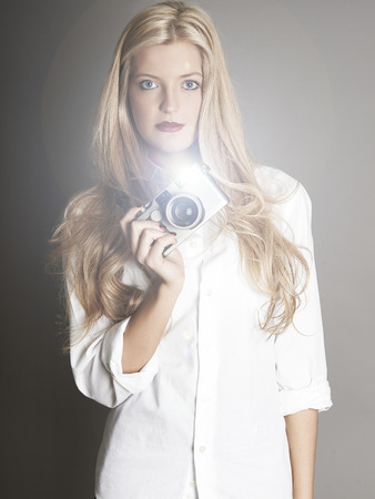 Pretty blonde girl holding cameraの写真素材