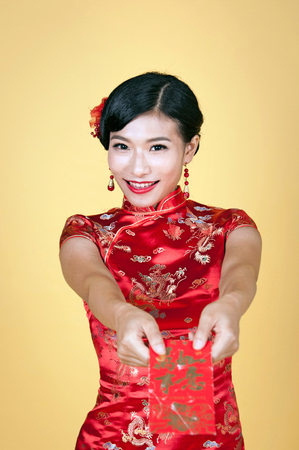 pretty chinese young woman holding red pocket for happy chinese new yearの写真素材
