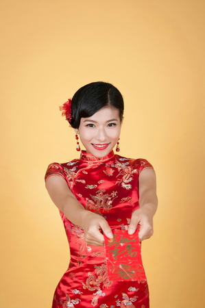 pretty chinese young woman holding red pocket for happy chinese new yearの写真素材
