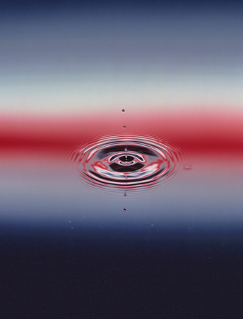 Drops hitting surface of water close-upの写真素材