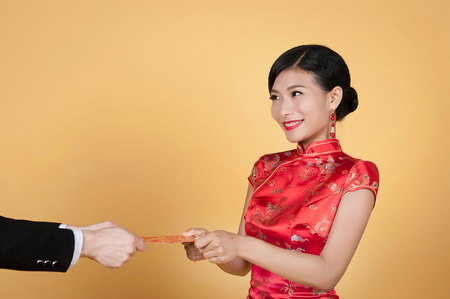 pretty chinese young woman receiving red pocket for happy chinese new yearの写真素材