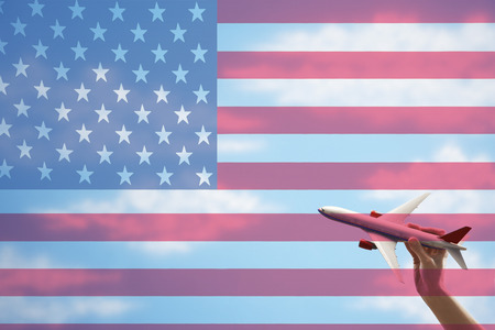 Toy plane flying in front of US flagの写真素材