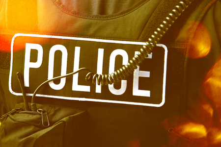 Closeup rear view of policeman's sign and cord on protective jacketの写真素材