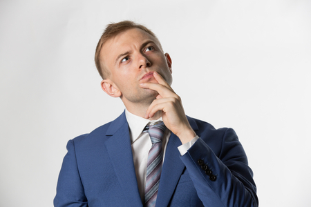 Businessman with finger on lips thinkingの写真素材