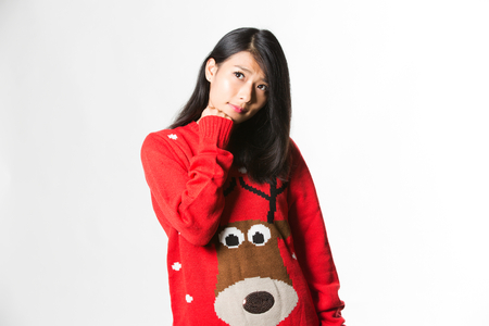Portrait of woman in Christmas sweater standing thinking about the futureの写真素材
