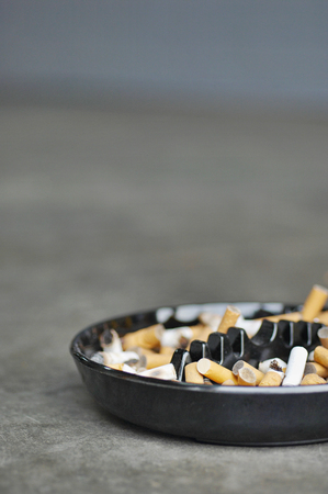 Full ashtray of cigarettes on table, close-upの写真素材