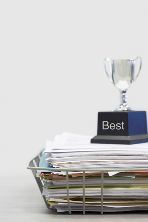 Trophy on Top of Papers saying bestの写真素材